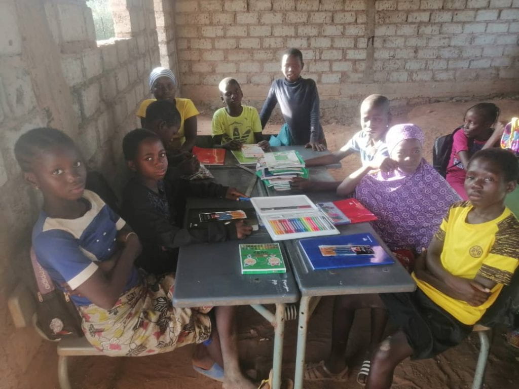  Young students in Dar Dalam, Kedougou, Senegal, sitting at desks using new school supplies made possible through a Small Change Better World grant.